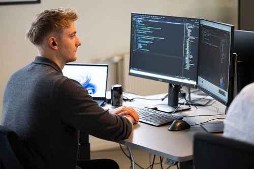 DK_ITM_udvikler sidder og arbejder på to computerskærme